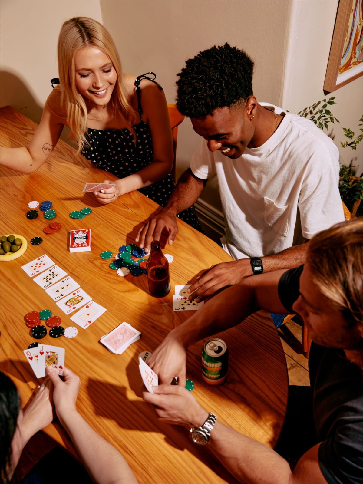 des amis qui rient et jouent ensemble autour d'une table au poker