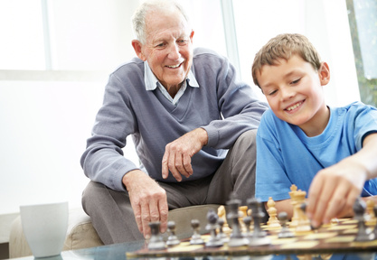 Grand père jouant aux échecs avec son petit-fils